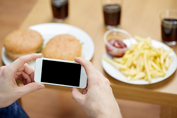 Image showing close up of man with smartphone picturing food