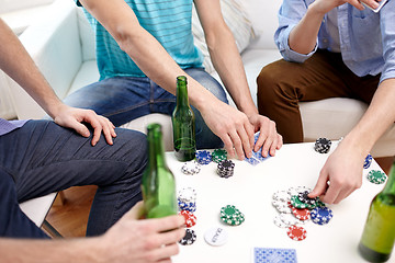 Image showing close up of male friends playing cards at home