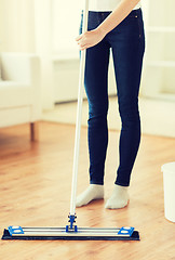 Image showing close up of woman with mop cleaning floor at home