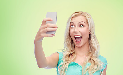 Image showing smiling young woman taking selfie with smartphone