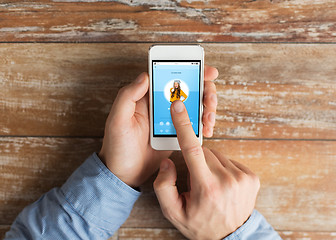 Image showing close up of male hands with smartphone on table