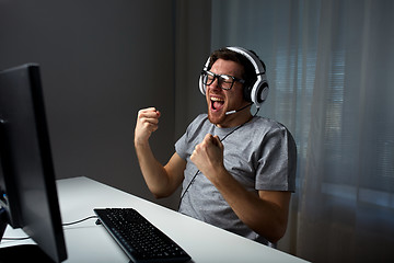 Image showing man in headset playing computer video game at home