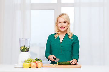 Image showing smiling woman with blender cooking food at home