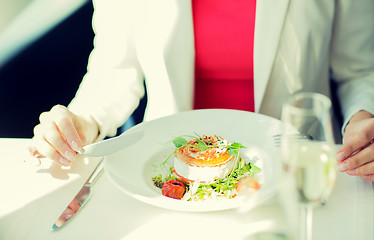 Image showing close up of woman eating salad at restaurant