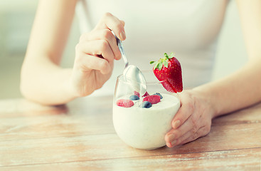 Image showing close up of woman hands with yogurt and berries