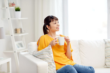 Image showing happy asian woman drinking from tea cup