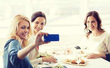 Image showing women with smartphone taking selfie at restaurant