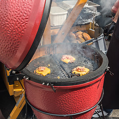 Image showing Beef burgers being grilled on food stall grill.