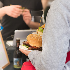 Image showing Beef burgers being served on street food stall