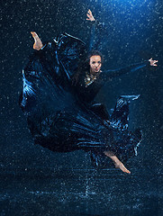 Image showing The young beautiful modern dancer dancing under water drops