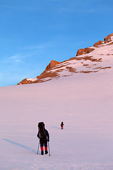 Image showing Two hikers in sunrise snowy plateau