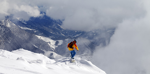 Image showing Snowboarder on off-piste slope an mountains in fog