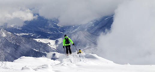 Image showing Freeriders on off-piste slope and mountains in mist