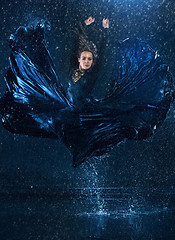 Image showing The young beautiful modern dancer dancing under water drops