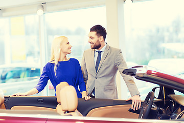 Image showing happy couple buying car in auto show or salon