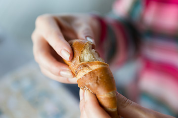 Image showing close up of woman hands with bun or wheat bread