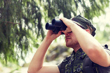 Image showing young soldier or hunter with binocular in forest