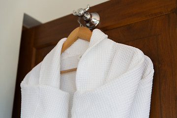 Image showing close up of white bathrobes on wooden hanger