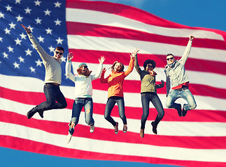 Image showing smiling friends in sunglasses jumping high