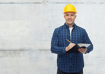 Image showing smiling male builder in helmet with clipboard