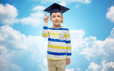 Image showing happy boy in bachelor hat pointing finger up