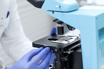 Image showing close up of hands with microscope and blood sample