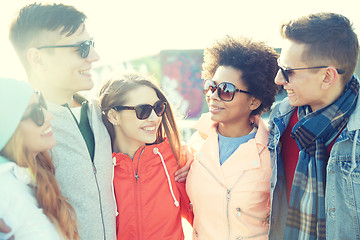 Image showing happy teenage friends in shades talking on street