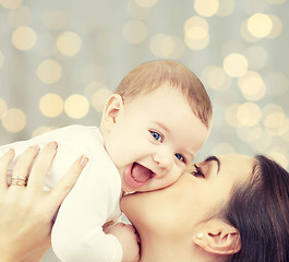 Image showing happy mother with baby over lights background