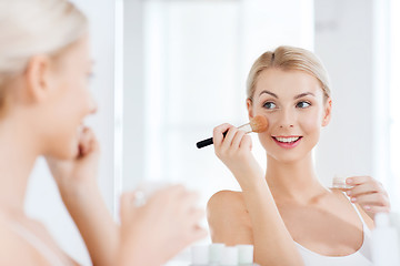 Image showing woman with makeup brush and powder at bathroom
