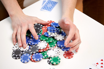 Image showing hands with casino chips making bet or taking win