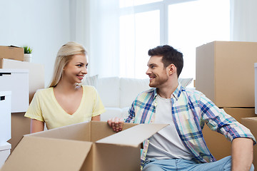 Image showing smiling couple with many boxes moving to new home