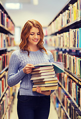 Image showing happy student girl or woman with books in library