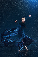 Image showing The young beautiful modern dancer dancing under water drops