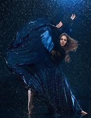 Image showing The young beautiful modern dancer dancing under water drops