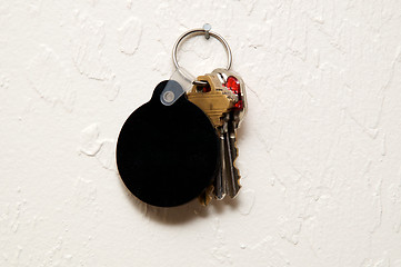 Image showing three keys on wall with round blank black fob