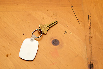 Image showing Keyring with key and fob on wood table