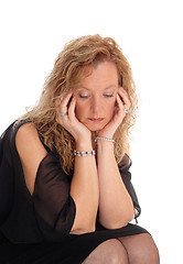 Image showing A sad looking blond woman sitting.