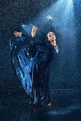 Image showing The young beautiful modern dancer dancing under water drops