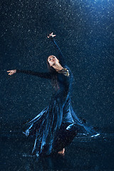 Image showing The young beautiful modern dancer dancing under water drops