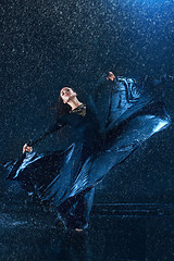 Image showing The young beautiful modern dancer dancing under water drops