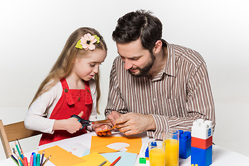 Image showing The daughter and father carving out paper applications 