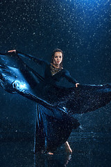 Image showing The young beautiful modern dancer dancing under water drops