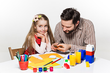 Image showing The daughter and father carving out paper applications 