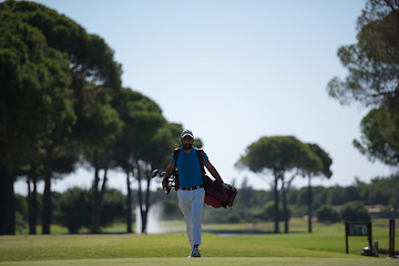 Image showing golf player walking and carrying bag