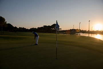 Image showing golfer hitting ball to hole