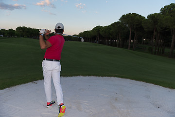 Image showing golfer hitting a sand bunker shot on sunset