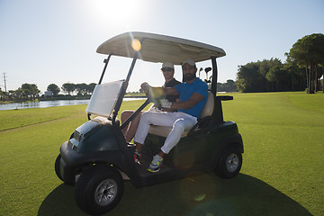 Image showing golf players driving cart at course