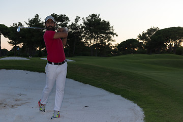 Image showing golfer hitting a sand bunker shot on sunset