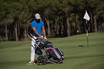 Image showing golf player walking with wheel bag