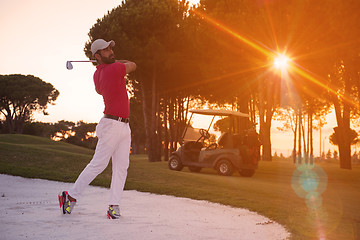 Image showing golfer hitting a sand bunker shot on sunset